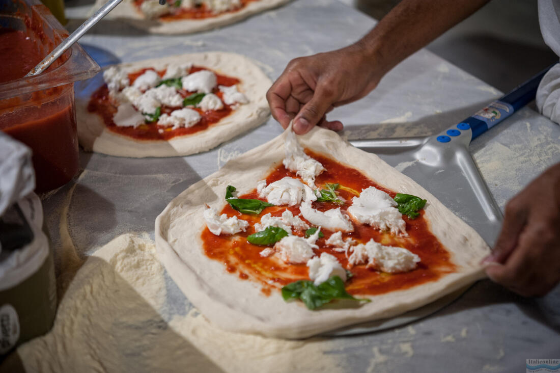 Pizzaiolo kładzie ciasto na pizzę na łopacie